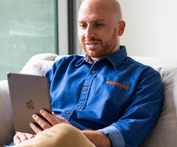 Online treatment for depression - man using ipad for online treatment